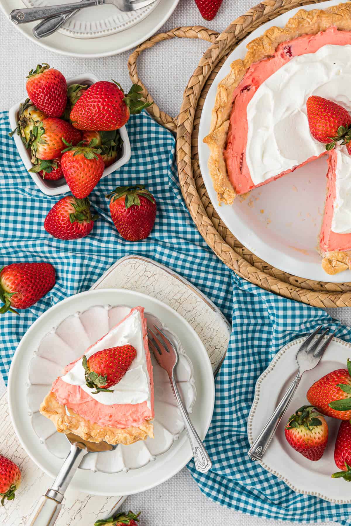 A slice of strawberry cream pie and the whole pie with a slice out.