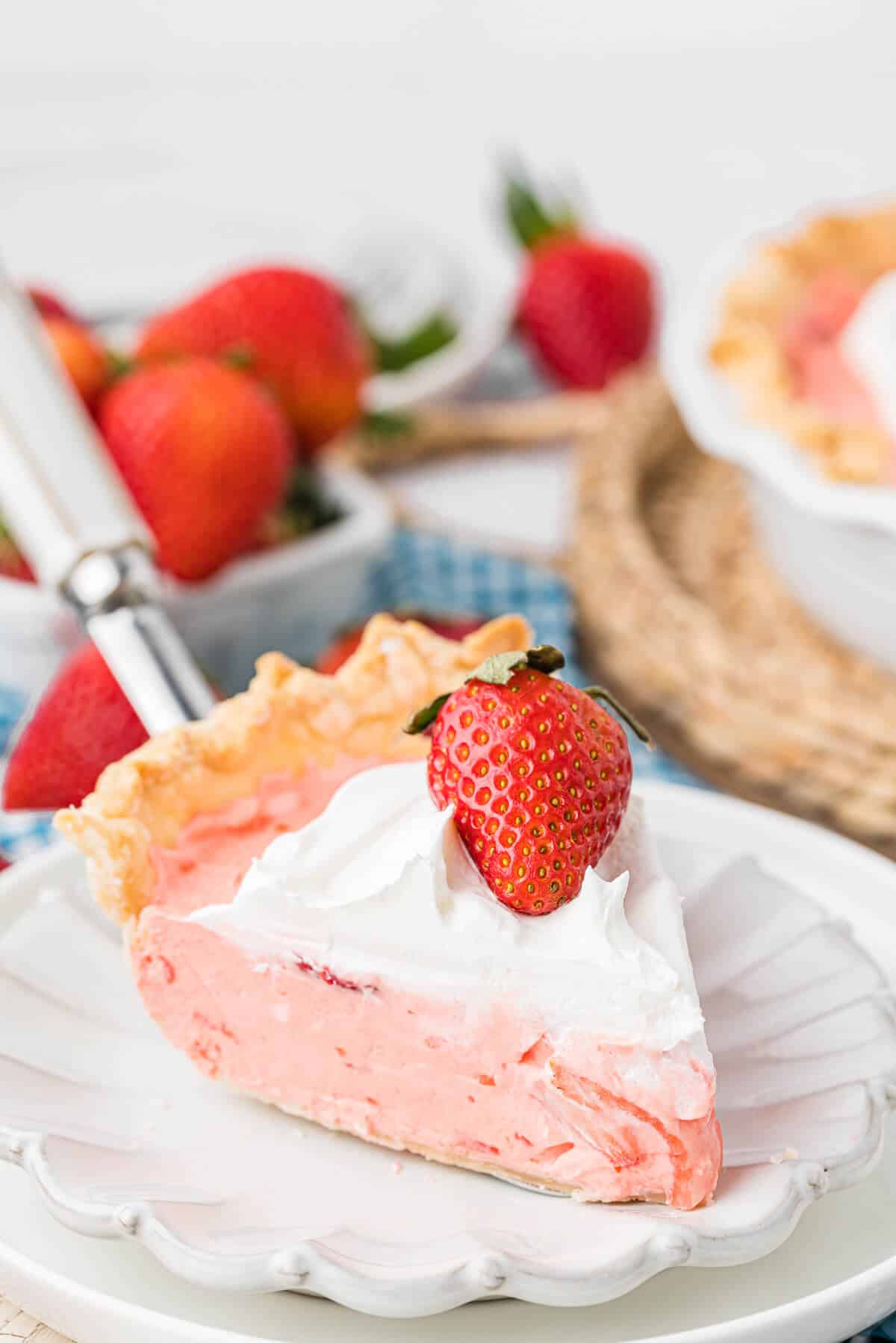 Strawberry cream pie slice being served on a white plate.