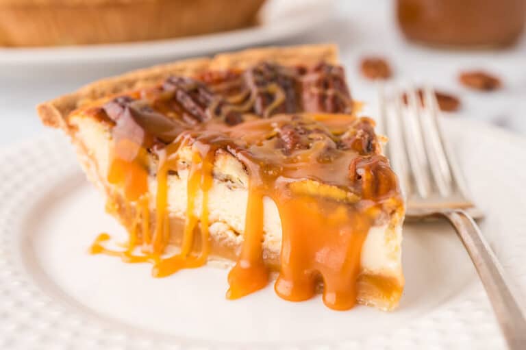 A slice of pecan pie cheesecake on a plate.