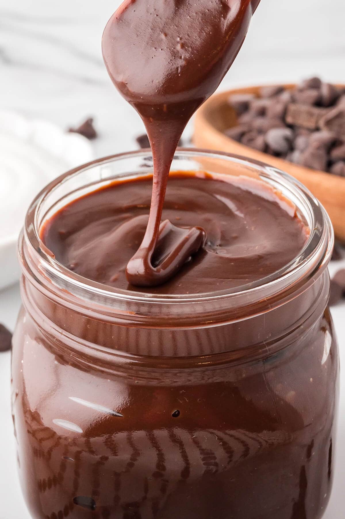 A spoon drizzling the recipe in a jar.