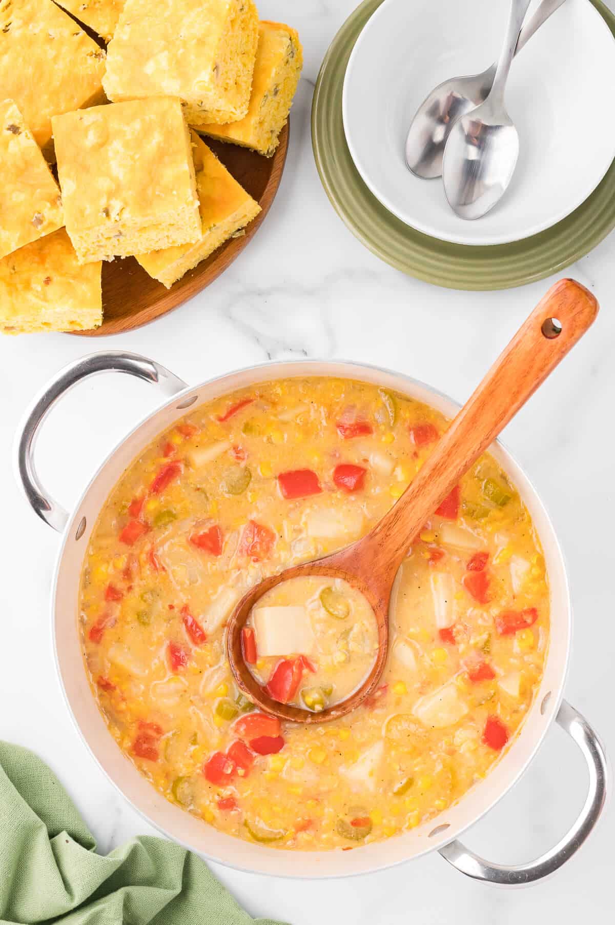 A pot of corn chowder with a ladle.