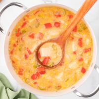 Corn chowder in a pot with a wooden ladle.