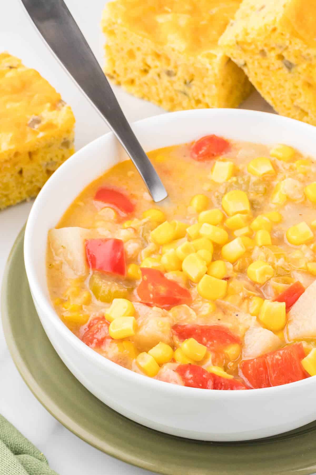 Corn chowder in a bowl with a spoon.