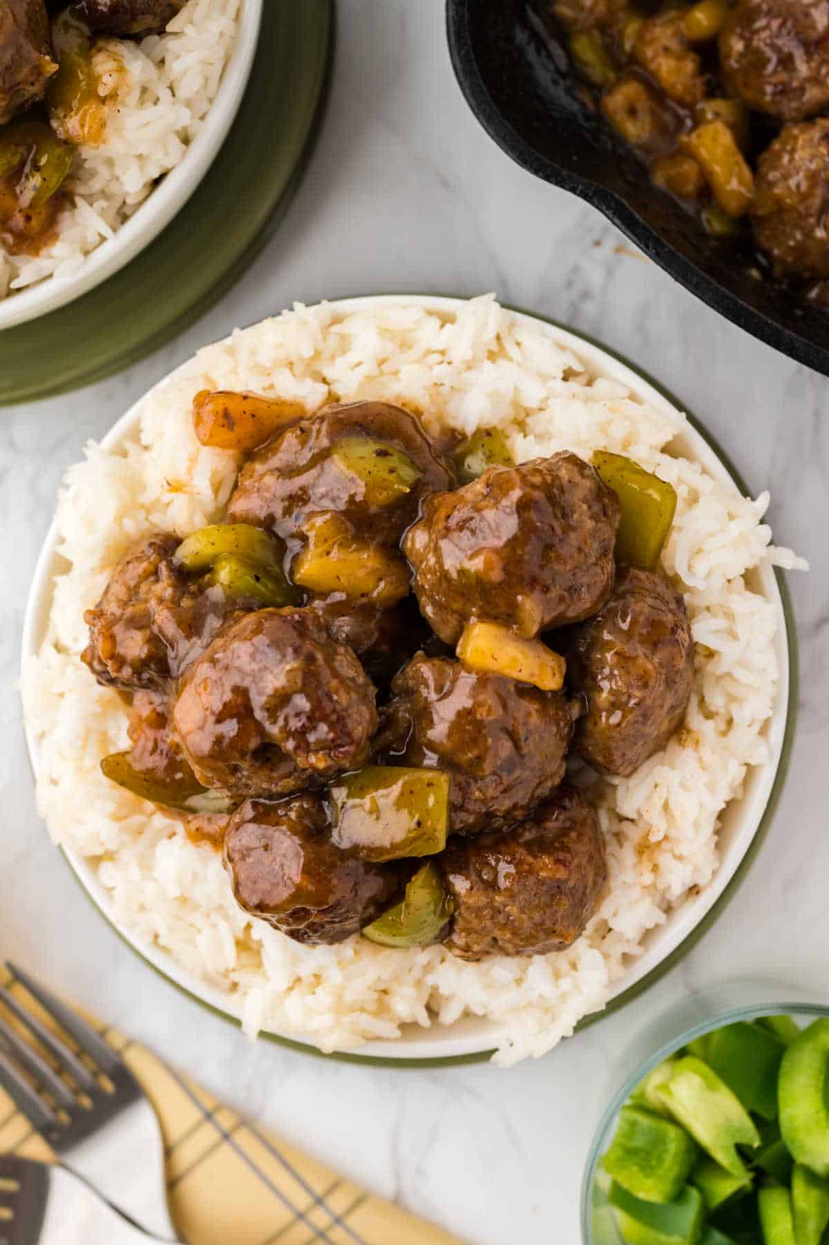 Waikiki meatballs on a bed of rice on a plate.