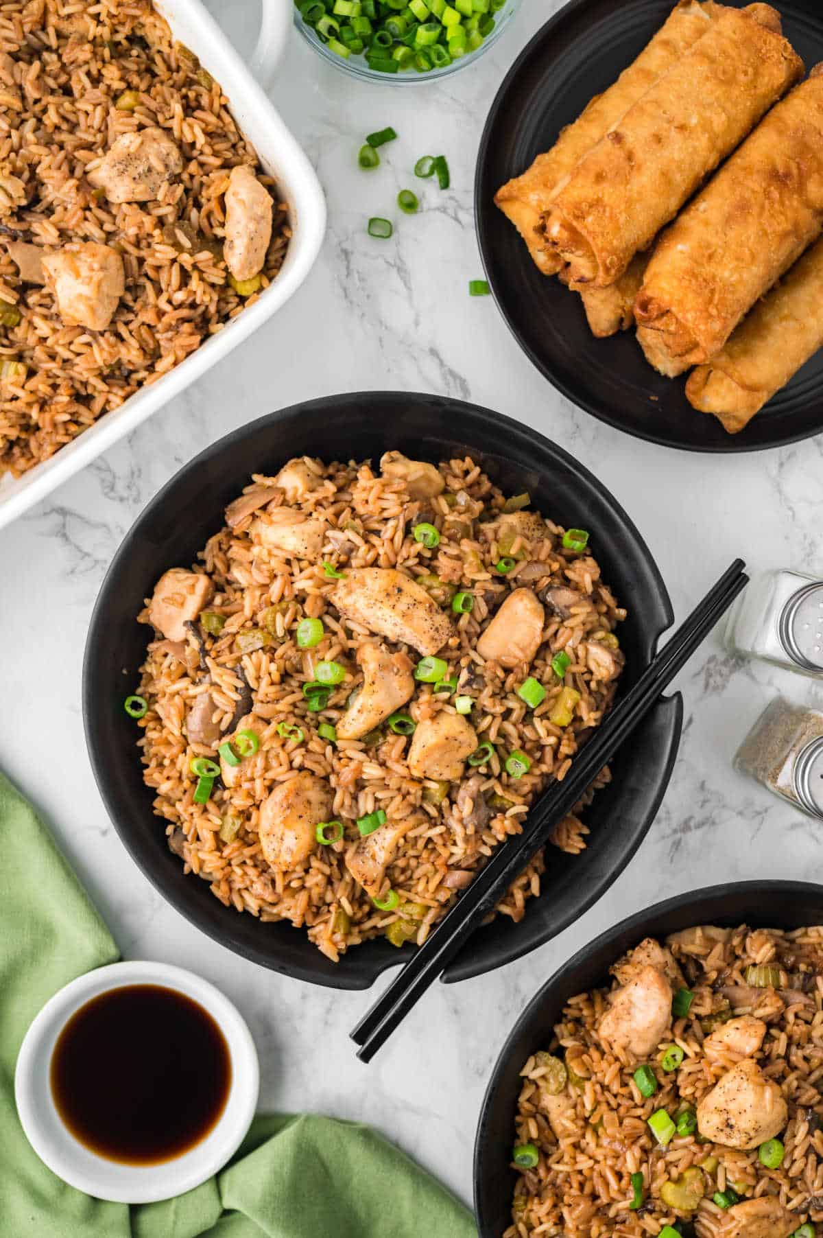 A black bowl of chicken fried rice.