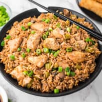 Chicken fried rice in a bowl with chopsticks.