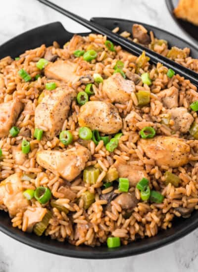 Chicken fried rice in a bowl with chopsticks.