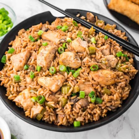 Chicken fried rice in a bowl with chopsticks.