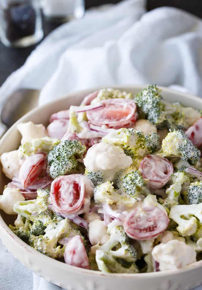 Christmas Salad - Contains all the colors of Christmas! This fresh, bright salad is made with broccoli, cauliflower, red onion and cherry tomatoes mixed with a creamy dressing.