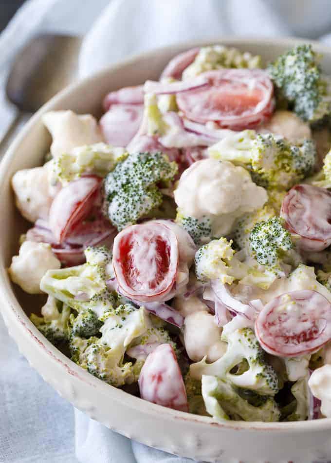 Christmas Salad - Contains all the colors of Christmas! This fresh, bright salad is made with broccoli, cauliflower, red onion and cherry tomatoes mixed with a creamy dressing.