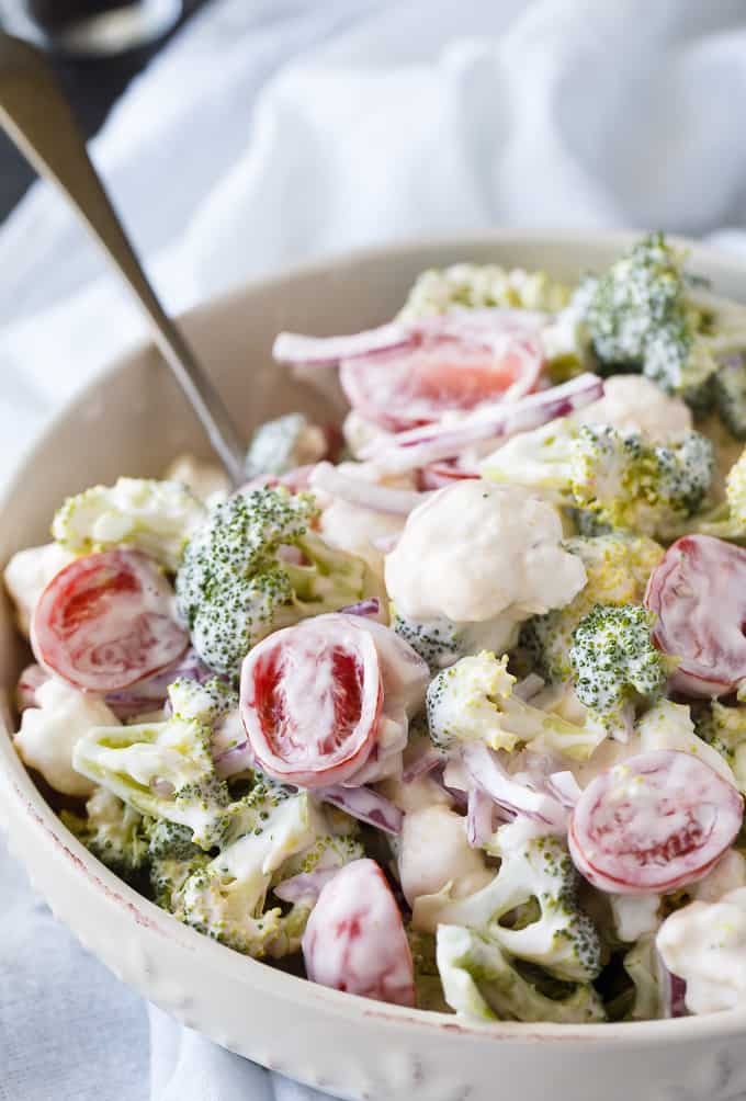 Christmas Salad - Contains all the colors of Christmas! This fresh, bright salad is made with broccoli, cauliflower, red onion and cherry tomatoes mixed with a creamy dressing.