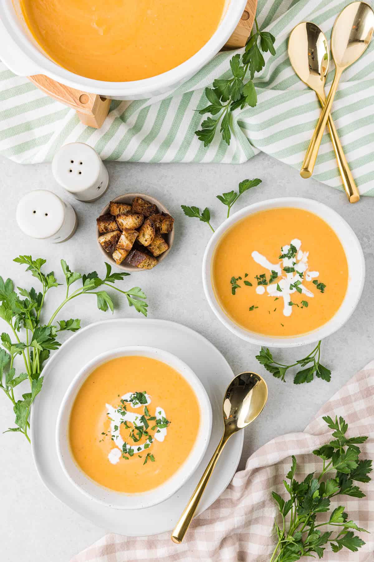 Two bowls of cream of carrot soup.