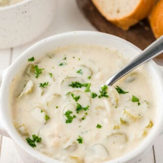 A bowl of cream of celery soup with a spoon.