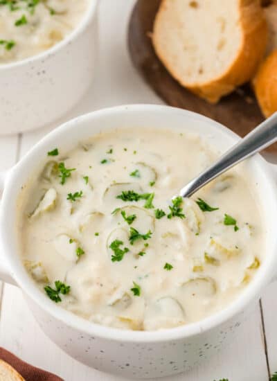 A bowl of cream of celery soup with a spoon.
