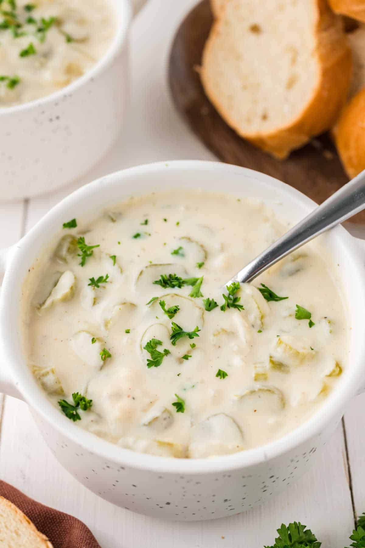 A bowl of cream of celery soup with a spoon.