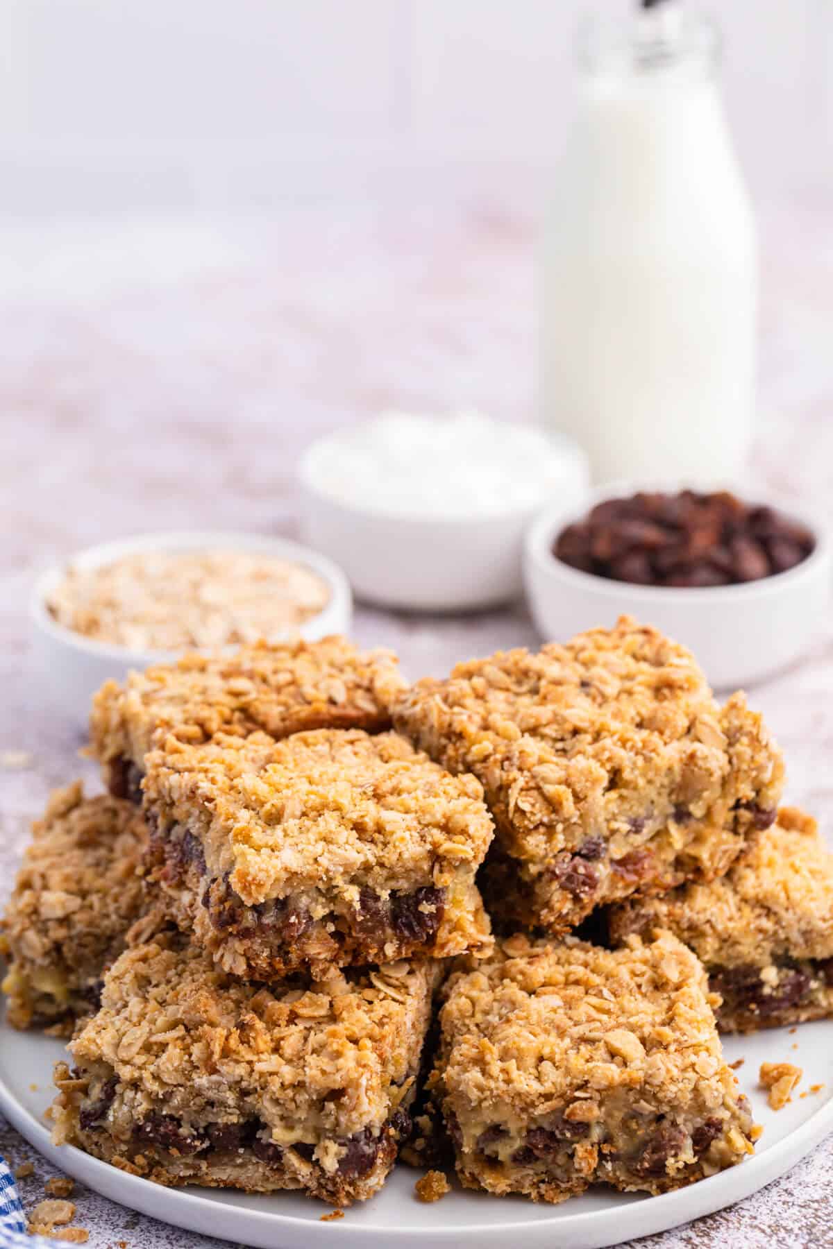 A group of sour cream raisin bars stacked on a plate.