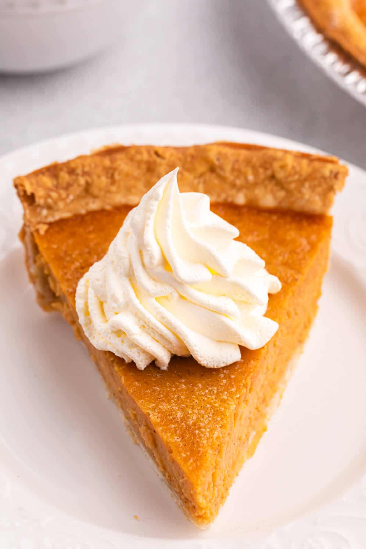 Sweet potato slice topped with whipped cream on a plate.