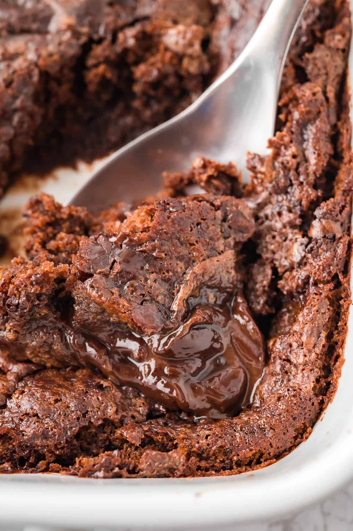 A pan of hot fudge pudding cake with a serving spoon in it.