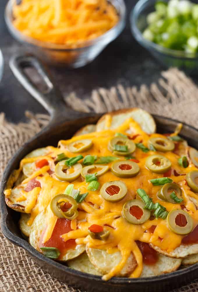 Potato Nachos - Crispy, flavorful potatoes loaded with taco sauce, green olives, green onions and lots of melty cheddar cheese. The perfect appetizer!