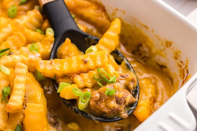 French fry Casserole in a pan with a serving spoon.