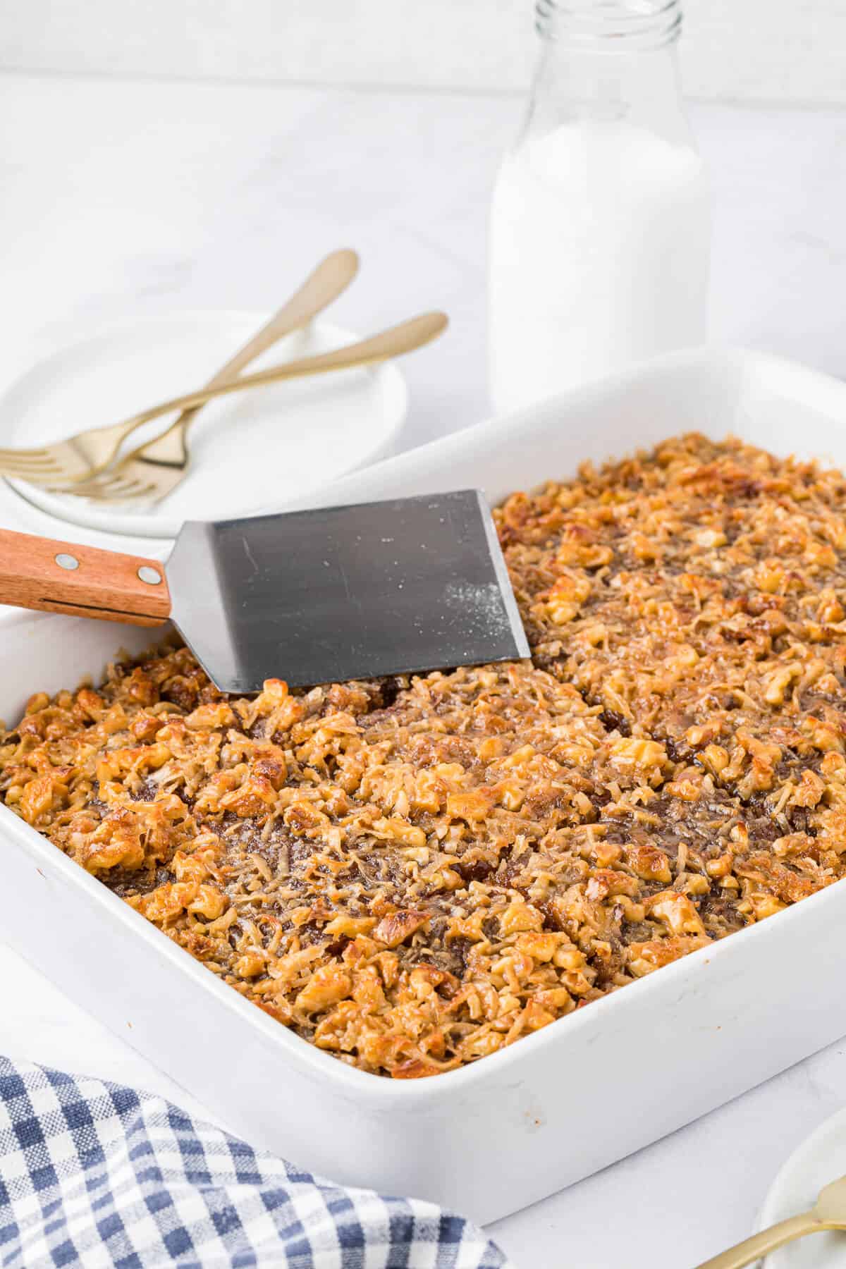 An oatmeal cake in a pan with a serving spatula on top.