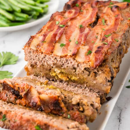 Sunday meatloaf on a platter with slices cut off the end.