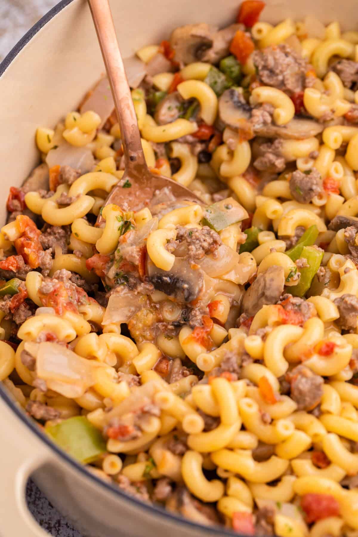 Mom's macaroni in a pot with a serving spoon.