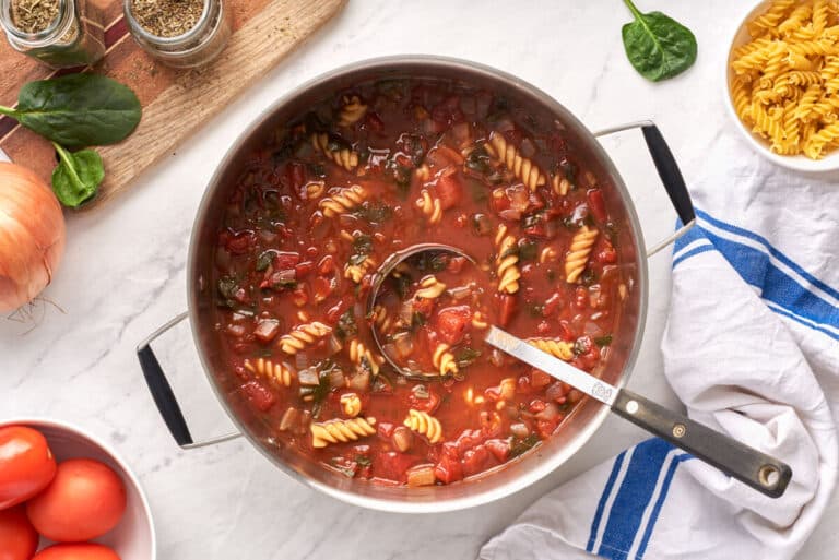 A pot of soup with a ladle.