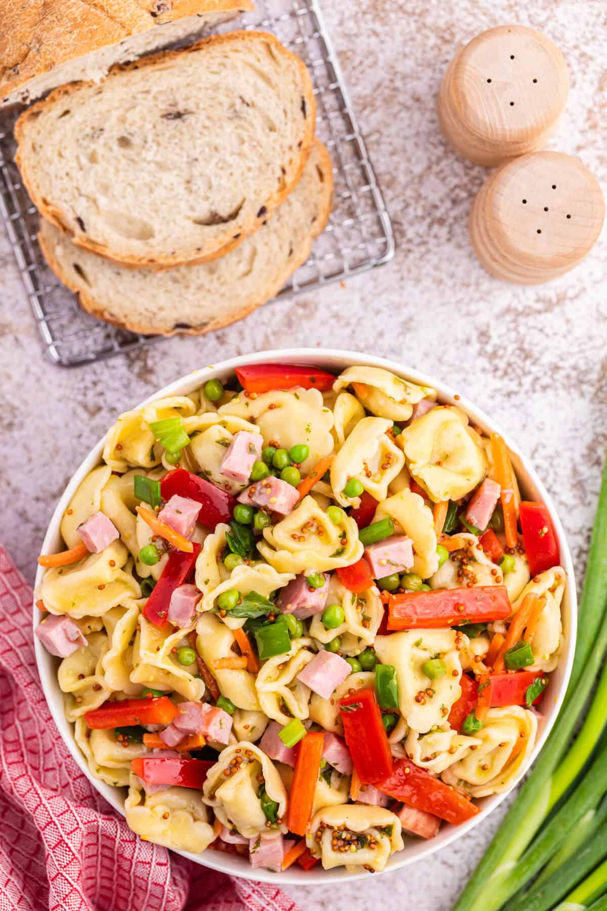 Tortellini salad in a white bowl.