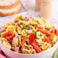 Tortellini salad in a white bowl.