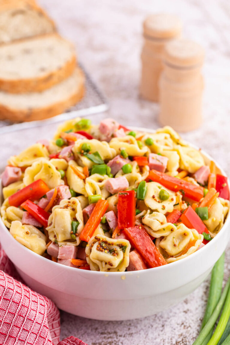 Tortellini salad in a white bowl.