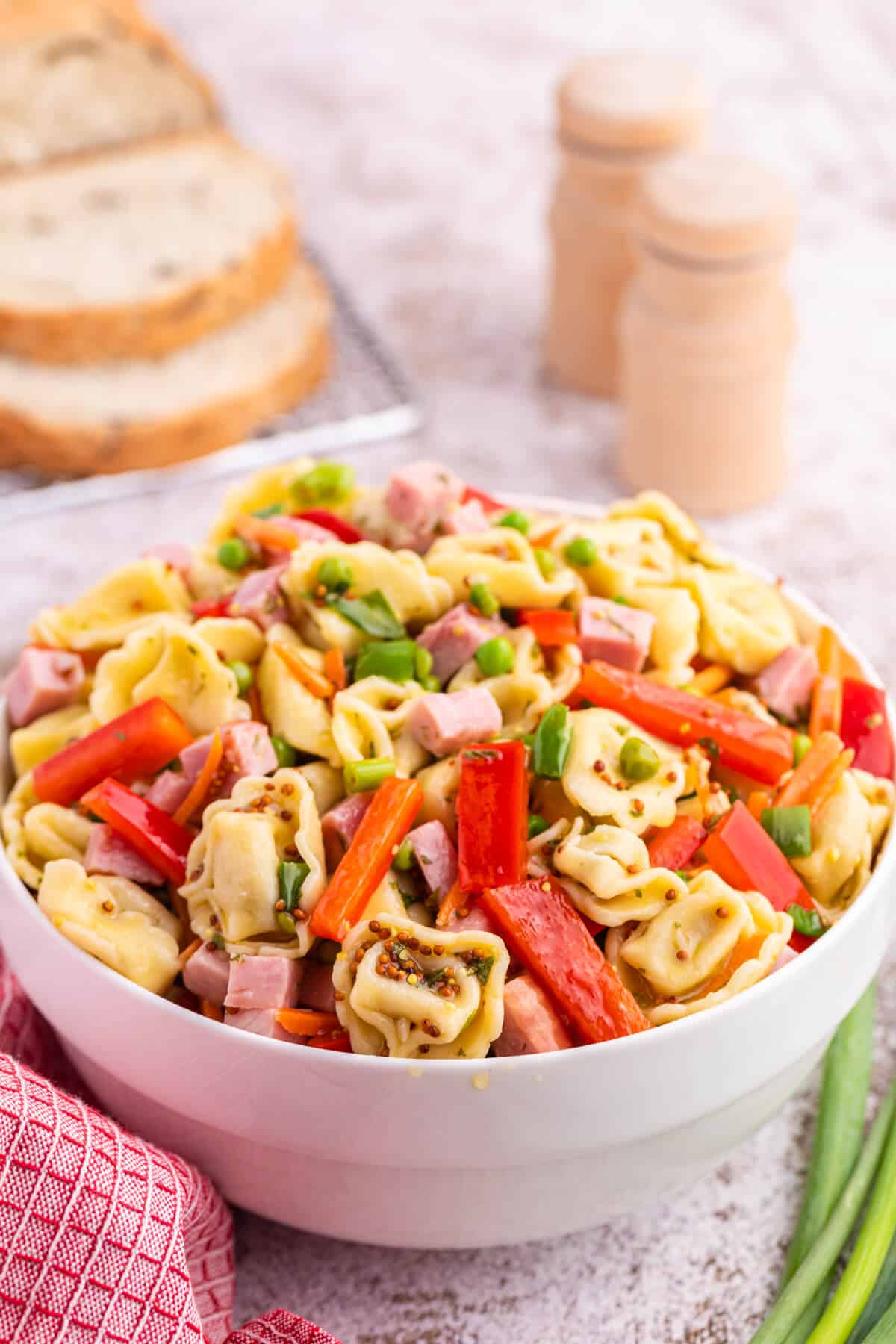 Tortellini salad in a white bowl.