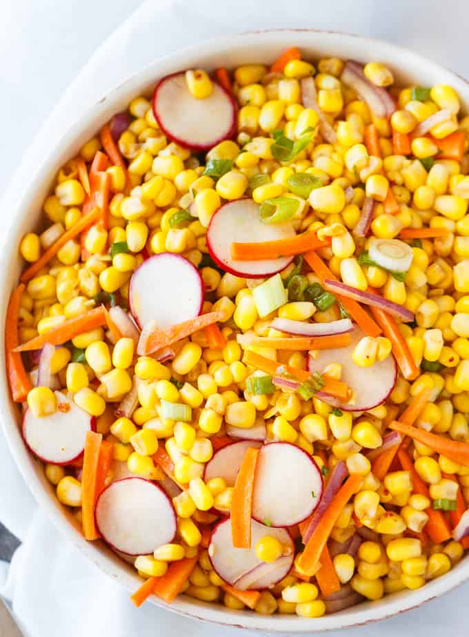 Corn Salad - Eat the rainbow with this recipe! Add some extra crunch to this simple summer side dish with carrots, radishes, red onions, and a simple salad dressing.