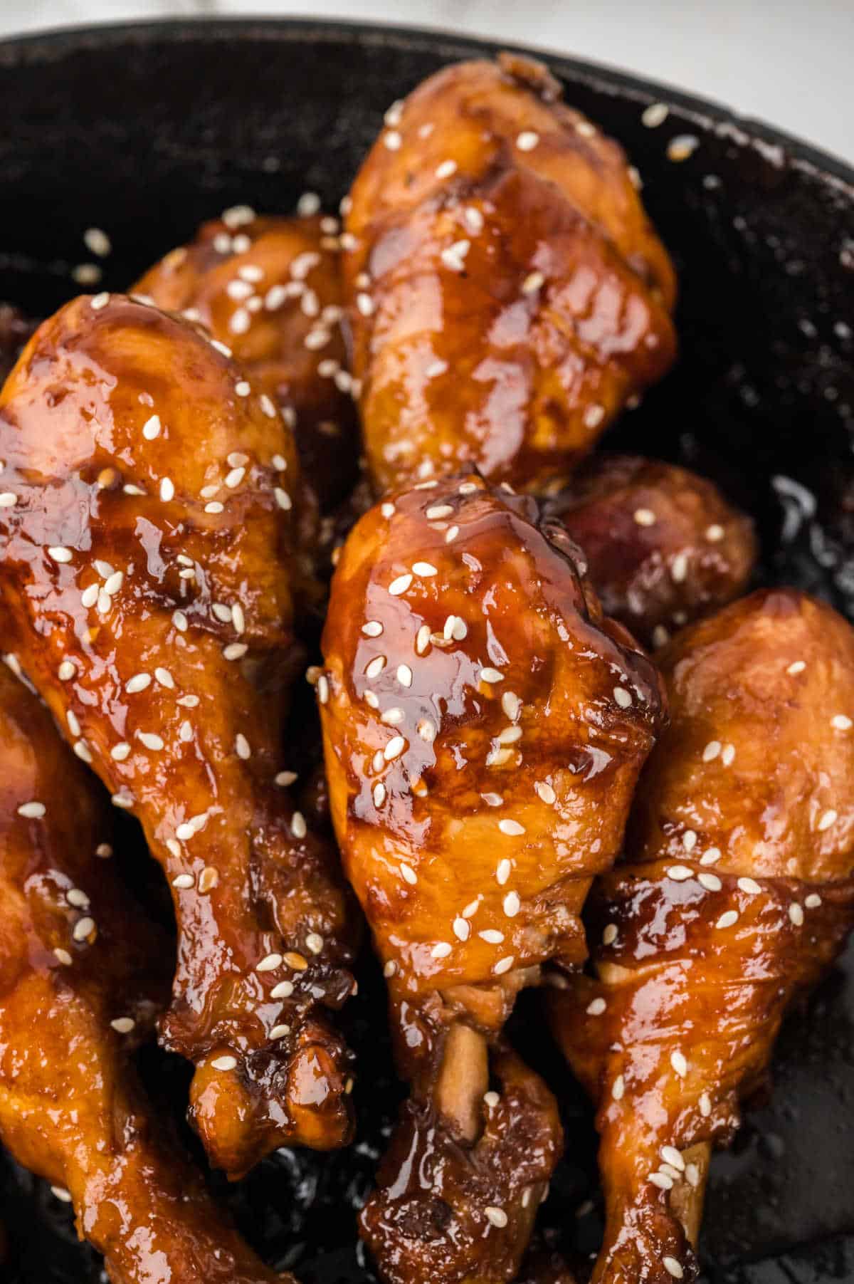 Sticky Chicken drumsticks in a pan.