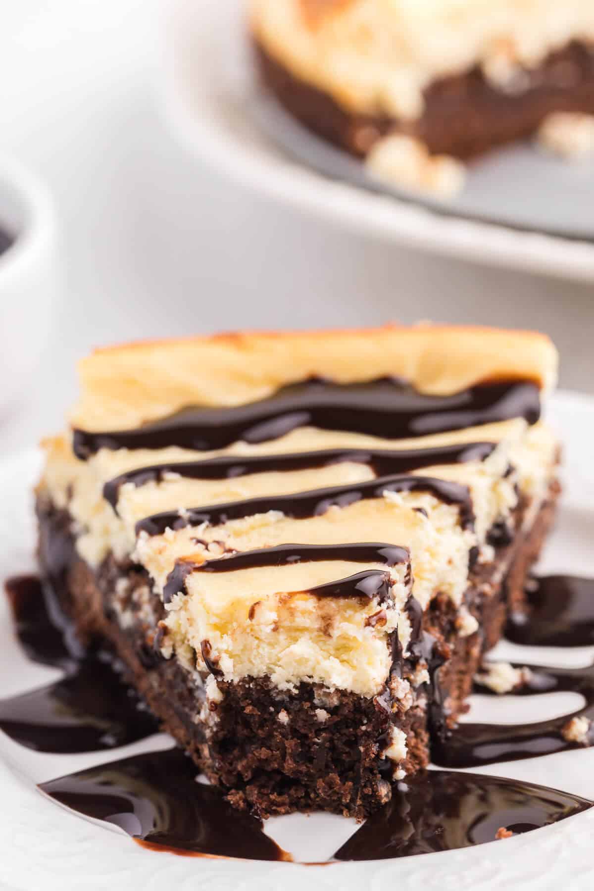 a slice of brownie bottom cheesecake with a bite out of the tip