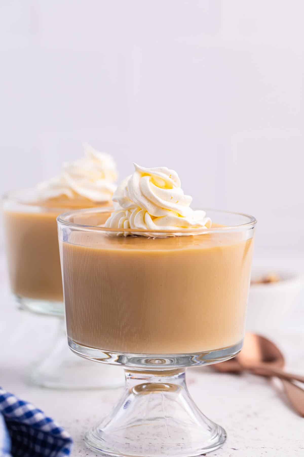 Butterscotch pudding in parfait dishes topped with whipped cream.