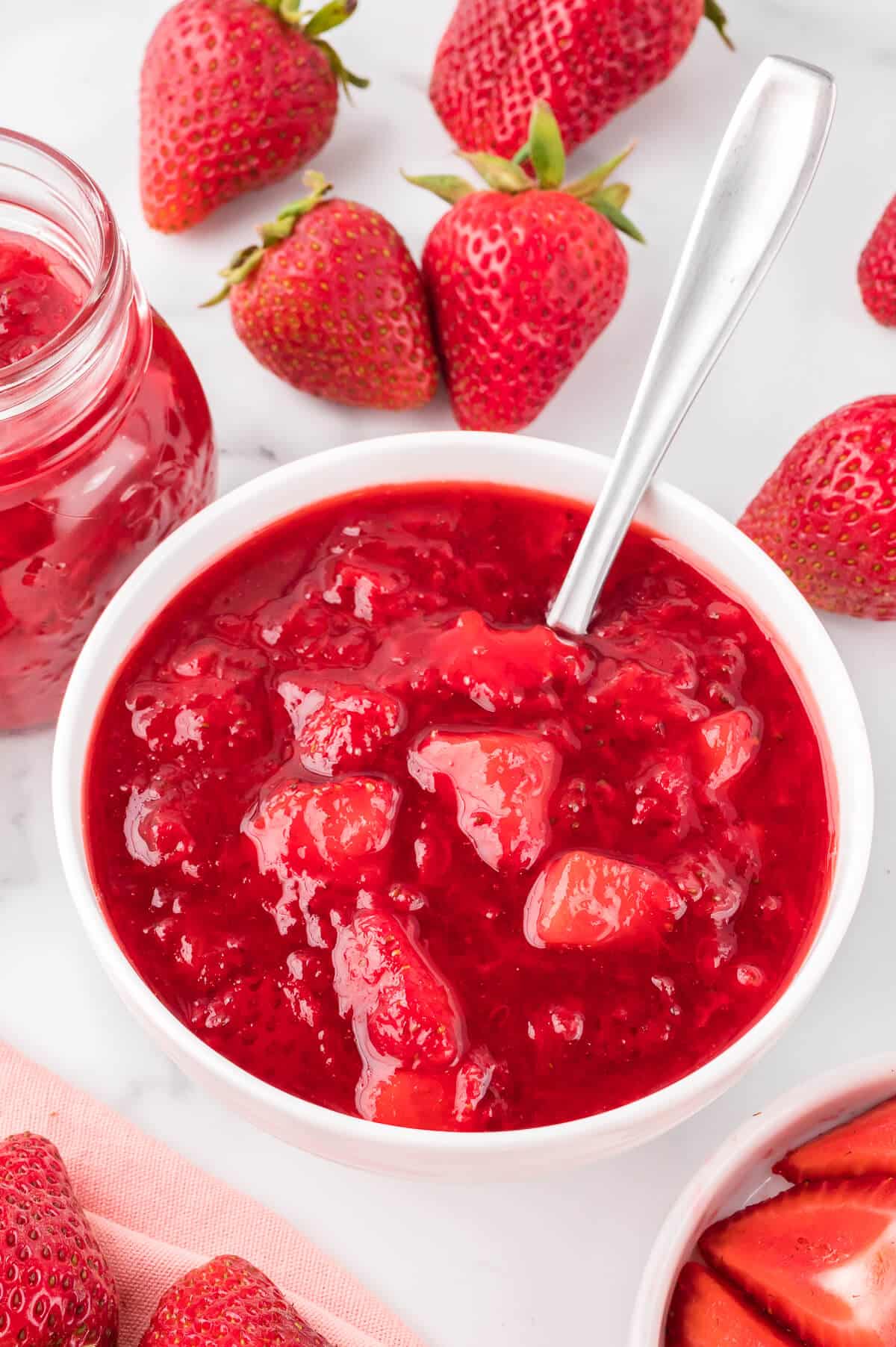 Strawberry sauce in a bowl with a spoon.