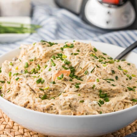 Slow cooker cream cheese chicken in a bowl with a spoon.