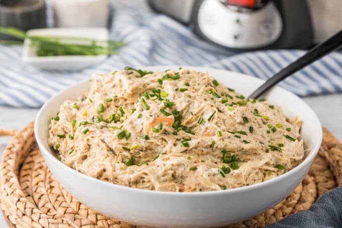 Slow cooker cream cheese chicken in a bowl with a spoon.