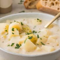 A bowl of German Potato Soup with a spoon.