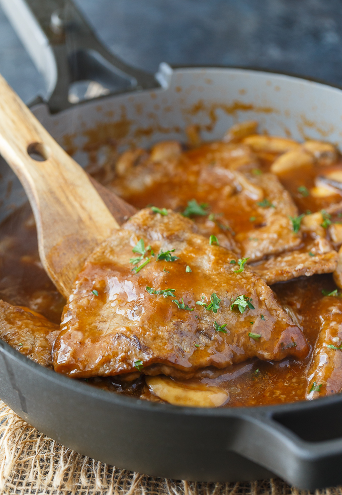 Mushroom Swiss Steak - Tender steak, mushrooms and onions are enveloped in a sweet and savory gravy. This easy dinner recipe pairs nicely with mashed potatoes to sop up all the delicious gravy.