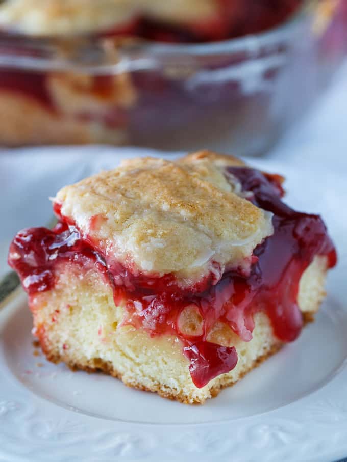 Cherry Cake - An easy, old-fashioned recipe that everyone adores! Moist cake is topped with sweet cherry pie filling and a sweet vanilla glaze.