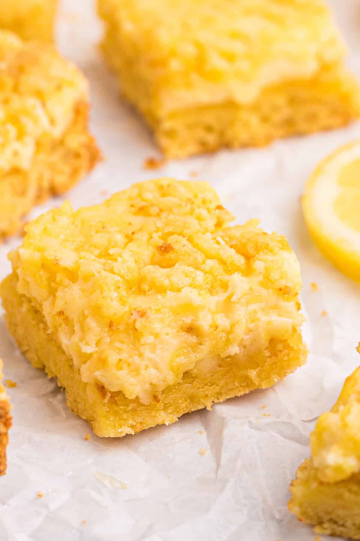 Lemon cheese bars on a parchment paper.