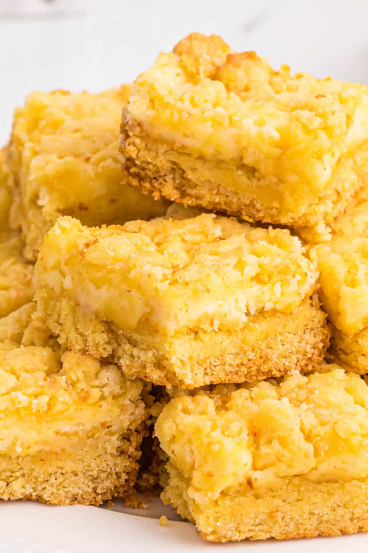 A pile of lemon cheese bars on a plate.