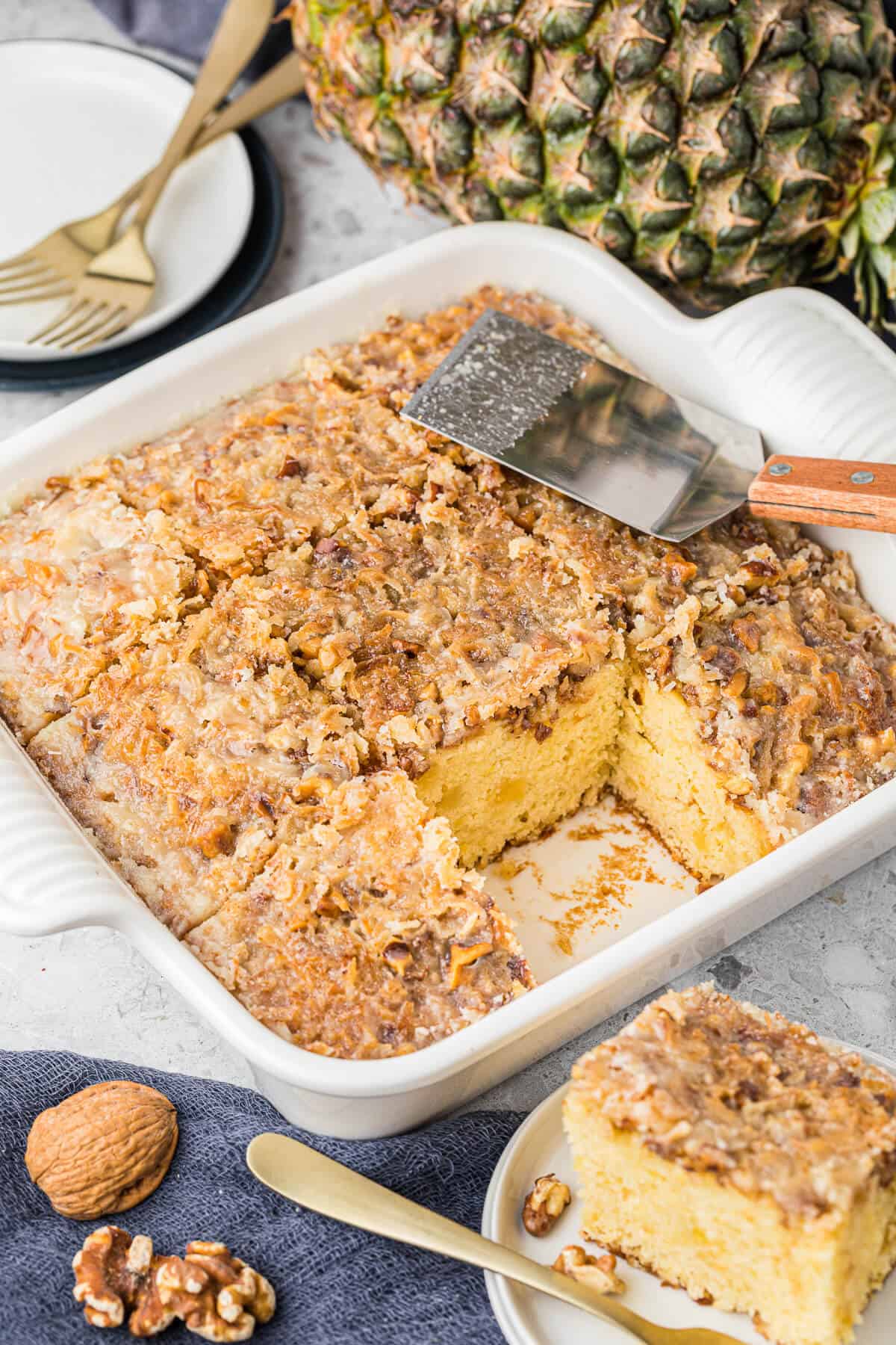 Pineapple cake in a pan with a piece cut out.