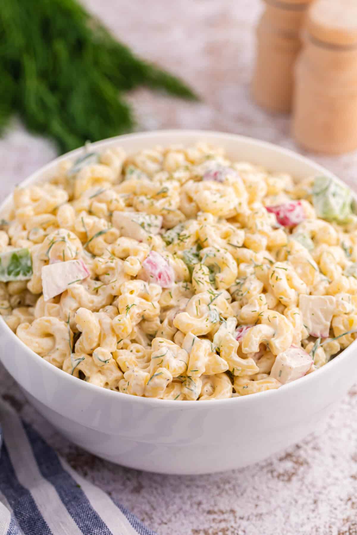 A white bowl with Macaroni Dill Salad.