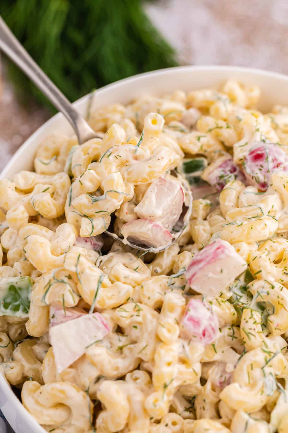 Macaroni dill salad in a bowl with a spoon.