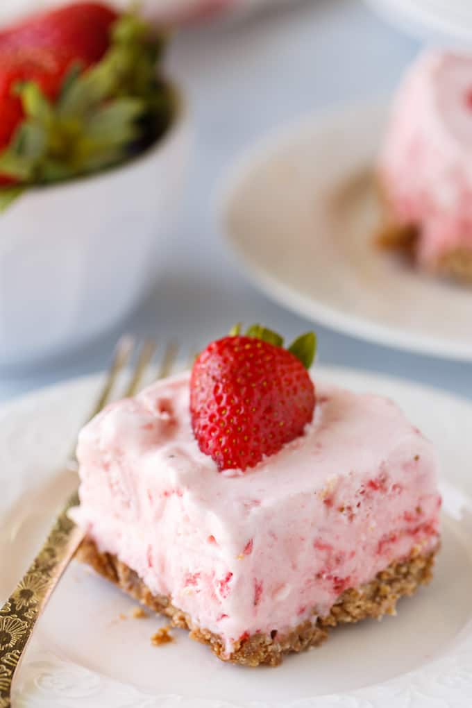 Frozen Strawberry Fluff - A sweet summer frozen delight! A buttery cookie crust is topped by a creamy, cold strawberry layer of yum.