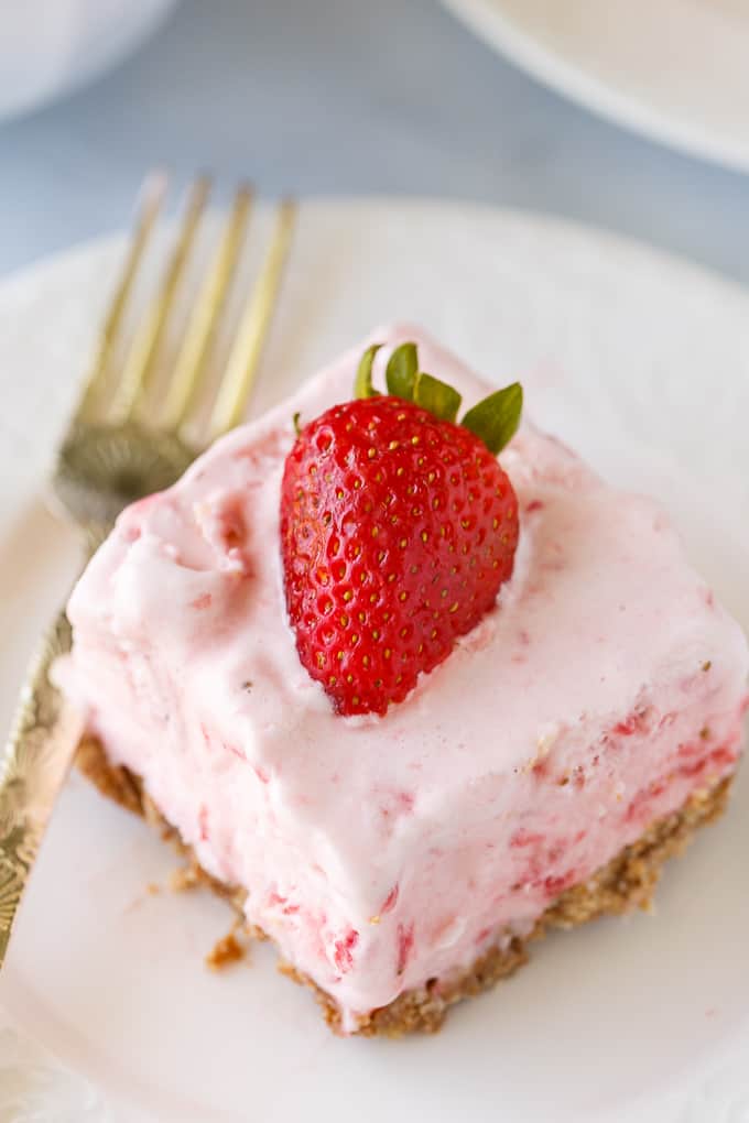 Frozen Strawberry Fluff - A sweet summer frozen delight! A buttery cookie crust is topped by a creamy, cold strawberry layer of yum.