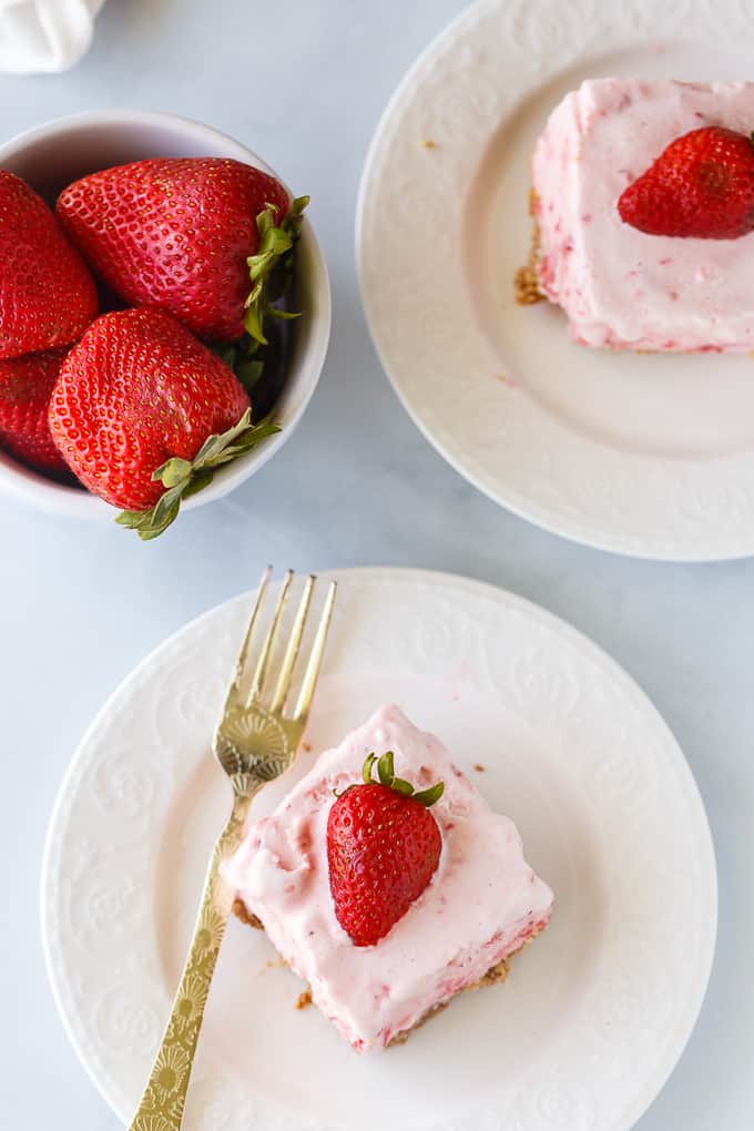 Frozen Strawberry Fluff - A sweet summer frozen delight! A buttery cookie crust is topped by a creamy, cold strawberry layer of yum.